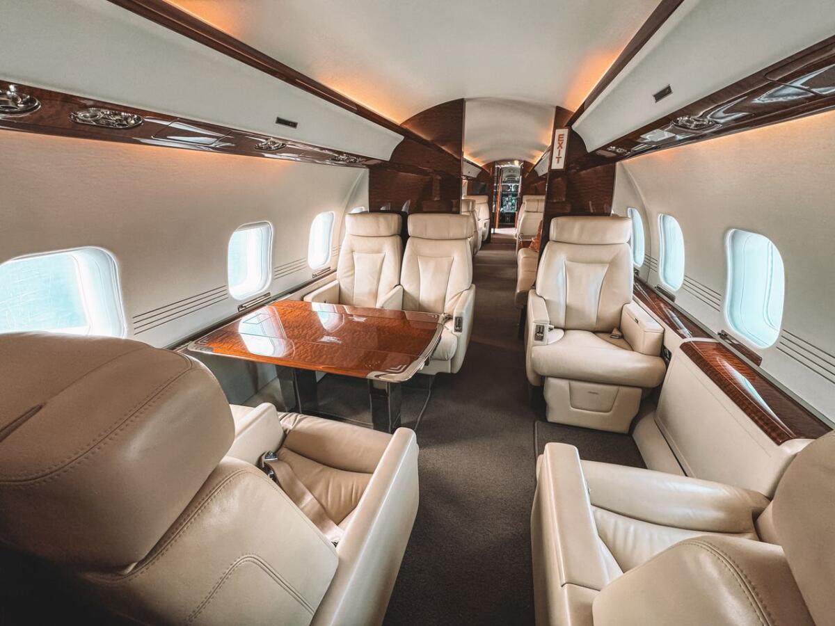missions Luxurious interior of a private jet showcasing leather seating and elegant wooden trim.